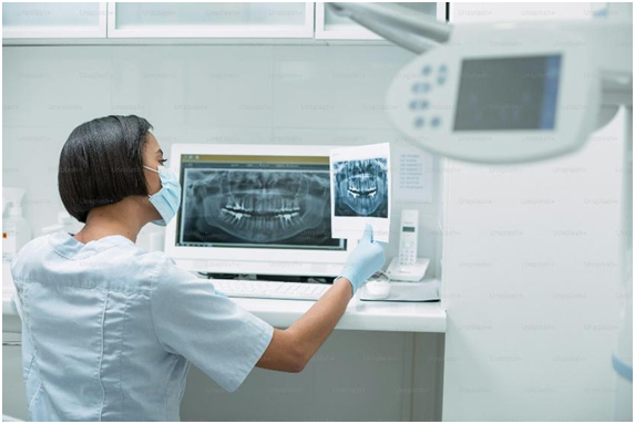 Dentist reviewing a panoramic dental x-ray on a monitor in a California clinic