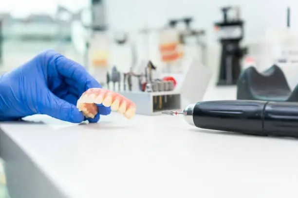 Dental technician creating a custom dental restoration in a dental prosthetic lab in California