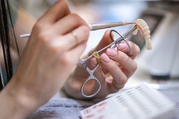 Dental technician shaping a dental prosthetic in a laboratory in California